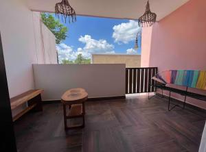 a room with a balcony with a bench and a table at Departamentos Naa'y in Valladolid