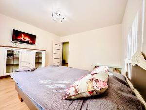 a bedroom with a bed and a tv on the wall at M&M Apartment VI SELF CHECK-IN in Panevėžys