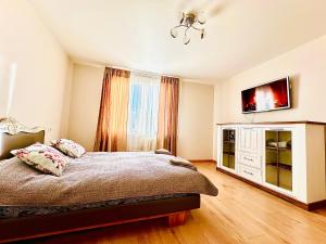 a bedroom with a bed and a flat screen tv at M&M Apartment VI SELF CHECK-IN in Panevėžys