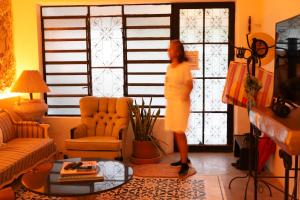 a woman standing in a living room looking out the window at Casa Arcana Boutique in Mérida