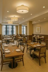 a restaurant with wooden tables and chairs and windows at The Grand Sanken Hotel in Kalodran