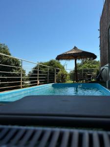 a swimming pool with an umbrella and a table at Los Monges Aparthotel in Ciudad del Este