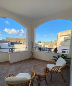 a balcony with chairs and a table and a window at Casa Vacanza la Civetta in Castri di Lecce