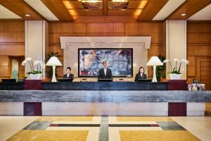 a lobby with four people sitting at a bar at Mandarin Oriental, Boston in Boston +95 photos