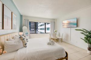 a bedroom with a large white bed and a table at Casablanca Residences Miami Beach in Miami Beach