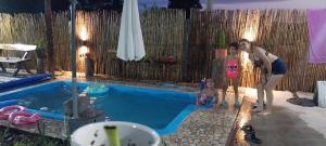 een man en een vrouw die naast een zwembad staan bij Quincho Gala in El Cadillal +8 foto's