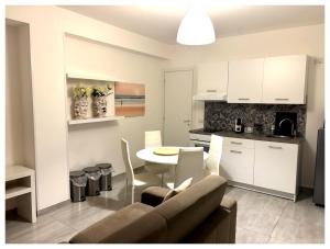 a kitchen and living room with a couch and a table at Anfitrite Suite Room in Pozzallo
