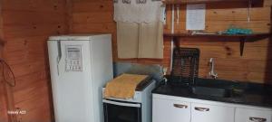 a small kitchen with a refrigerator and a sink at Cabañas Recanto do pepe in Santa Vitória do Palmar