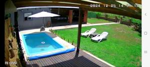 een uitzicht op een zwembad met 2 stoelen en een parasol bij Quincho Gala in El Cadillal