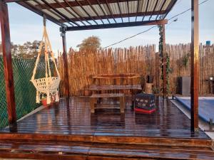 een terras met een schommel, een tafel en een bank bij Quincho Gala in El Cadillal