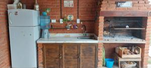 een keuken met een witte koelkast en een bakstenen muur bij Quincho Gala in El Cadillal