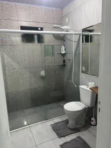 a bathroom with a glass shower with a toilet at Pool amid the green in Gaspar