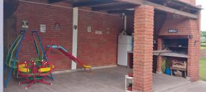 a brick patio with swings and an outdoor oven at Quincho Gala in El Cadillal