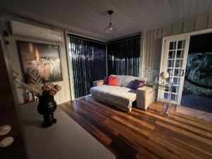 a living room with a white couch and wood floors at Pool amid the green in Gaspar +36 photos