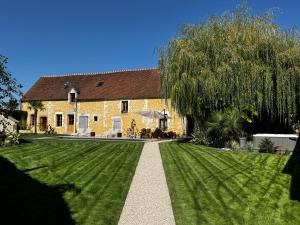 a house with a green lawn in front of it at Le Relai Valdieu in Courgeon