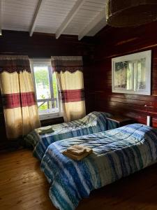 a bedroom with two beds and two windows at Lomas Del Delta in Esquina