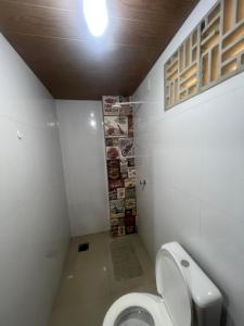 une petite salle de bain avec toilettes et lumière dans l'établissement Quarto privado próximo ao centro, à Manaus