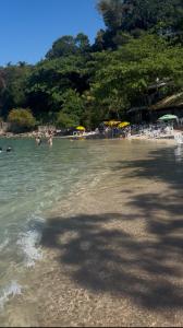 a group of people in the water at a beach at Suite Tarituba 3 in Angra dos Reis