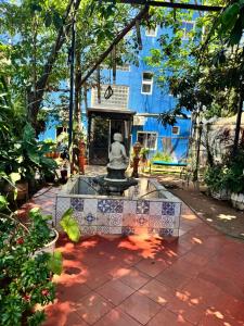 a statue in a garden with a blue building at Los Monges Aparthotel in Ciudad del Este +7 photos
