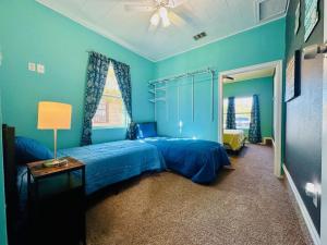 a blue bedroom with a bed and a window at Yellow Texas Star House blocks from Goodfellow AFB in San Angelo +6 photos