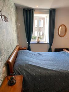 a bedroom with a blue bed and a window at Résidence du lion d'or in Conflans
