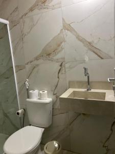 a bathroom with a white toilet and a sink at Suite Tarituba 3 in Angra dos Reis