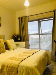a bedroom with a bed with a large window at Apartment at the Blyde in Pretoria