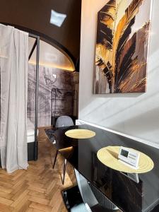 a room with two tables and a painting on the wall at Moonlight City Center Studio Private Parking in Cluj-Napoca
