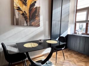 a dining room with a black table and chairs at Moonlight City Center Studio-Private Parking, king in Cluj-Napoca
