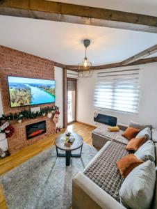 兹拉蒂博尔Zlatiborske noći的带沙发和砖墙的客厅