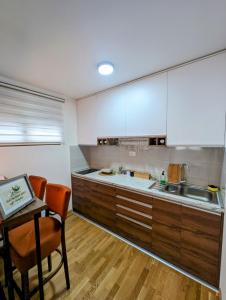 兹拉蒂博尔Zlatiborske noći的厨房配有木制橱柜、桌子和桌子。