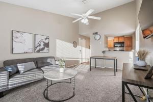 una sala de estar con un sofá y una mesa en District West Apartments Simple Modern Home, en Doud