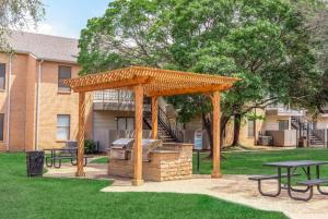 Una pérgola de madera con parrilla en un patio. en District West Apartments Simple Modern Home, en Doud