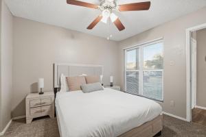 Un dormitorio con una cama blanca y un ventilador de techo. en District West Apartments Simple Comfort & Value, en Doud 24 fotos más