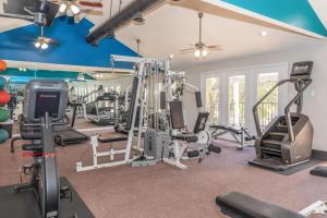 un gimnasio con cintas de correr y equipos de ejercicio en una casa en District West Apartments Simple Comfort & Value, en Doud