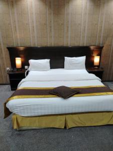 a large bed in a hotel room with two lamps at اصيل الفاخره المخدومه in Taif
