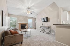 een woonkamer met een bank en een open haard bij District West Apartments Comfort Made Simple in Doud