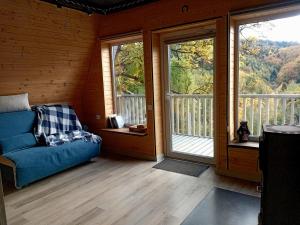 a living room with a blue couch and two windows at М'юзіка Карпат in Yavoriv +15 photos