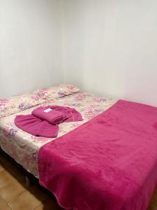 Una cama con una manta morada encima. en Quarto privado no centro 313, en Manaus