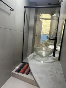 a bathroom with a bowl sink in a glass case at Oxx Quarto Rio in Congonhas
