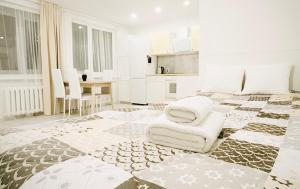 een witte slaapkamer met een groot bed en een stoel bij M&M Apartment I SELF CHECK-IN near Panevezys in Velžys