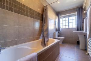een badkamer met een bad en een toilet bij Gouveia Forest Guest House in Gouveia +53 foto's