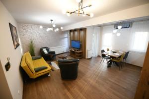 a living room with a yellow chair and a table at Cristal Palace Suites 004 in Kragujevac