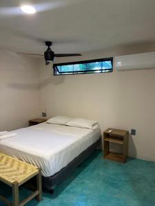 a bedroom with a white bed and a window at La punta surfhouse 2 in Puerto Escondido