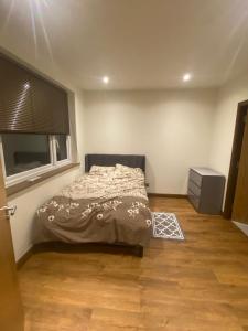 a bedroom with a bed and a window and a wooden floor at Newly Furnished, Ensuite Room with a Private Entrance in Colindale