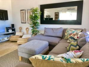 a living room with a couch and a mirror at Cadaques Bayahibe Family Apts in Bayahibe
