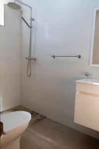 a white bathroom with a toilet and a sink at Quarto com Vista para o Vale in Ribeira Grande