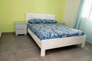 a bedroom with a bed with a blue and white comforter at Quarto com Vista para o Vale in Ribeira Grande