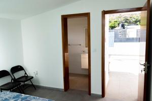 a bedroom with a door leading to a balcony at Quarto com Vista para o Vale in Ribeira Grande