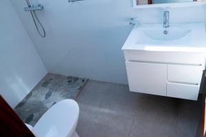a bathroom with a white sink and a toilet at Quarto com Vista para o Vale in Ribeira Grande